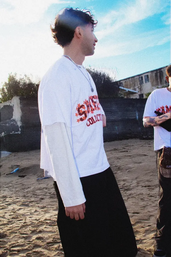 Ragazzo di profilo in spiaggia con la t-shirt Sametics
